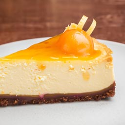 Classic creamy cheesecake with a graham cracker crust, topped with your choice of fruit compote.